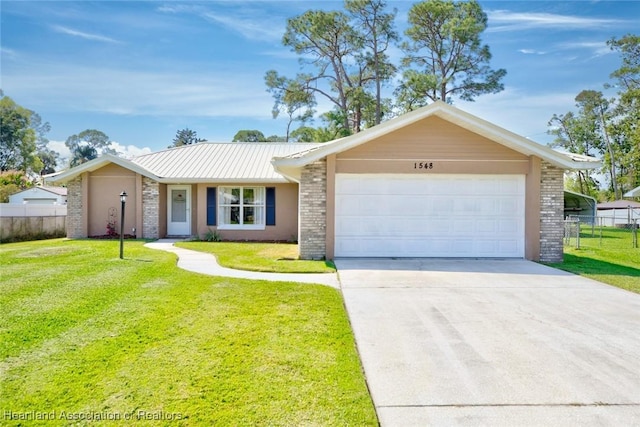 single story home with a garage, brick siding, a front lawn, and fence