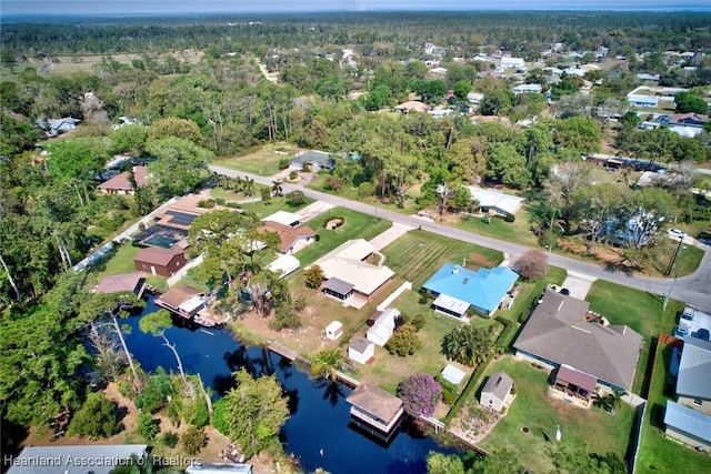 birds eye view of property featuring a water view, a residential view, and a wooded view