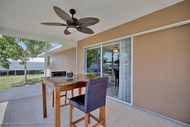 view of patio featuring ceiling fan, outdoor dining area, and fence