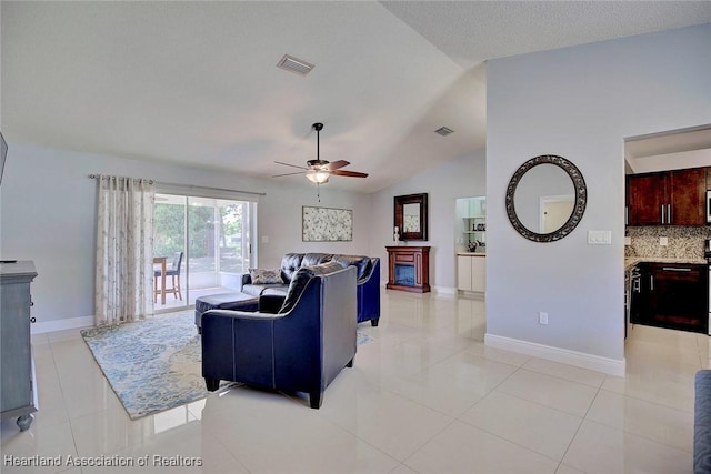 living room featuring lofted ceiling, light tile patterned floors, visible vents, and baseboards