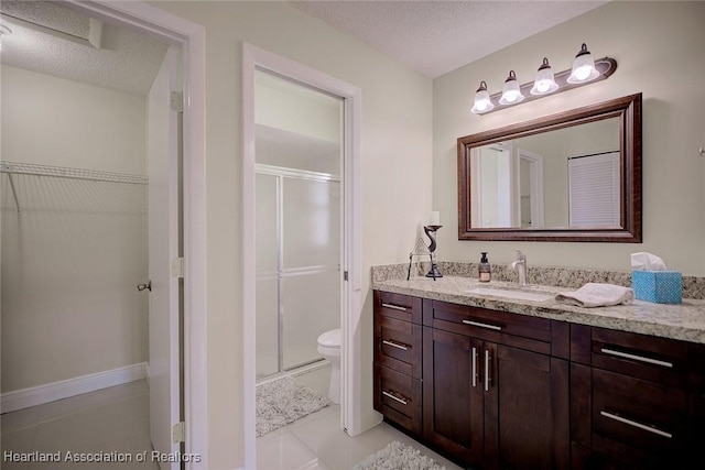 bathroom featuring toilet, a shower stall, a textured ceiling, and vanity