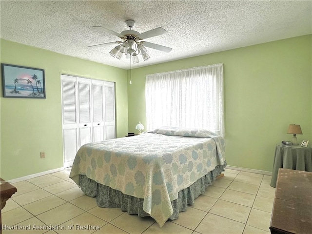 tiled bedroom with a textured ceiling, a closet, and ceiling fan