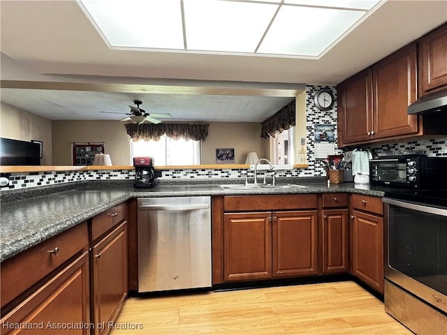 kitchen with ceiling fan, dishwasher, sink, decorative backsplash, and range