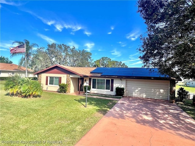 ranch-style home with solar panels, a garage, and a front lawn