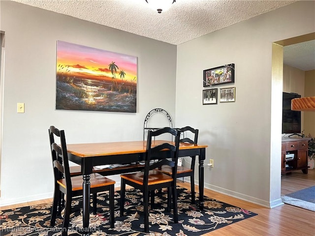 dining area featuring hardwood / wood-style floors and a textured ceiling