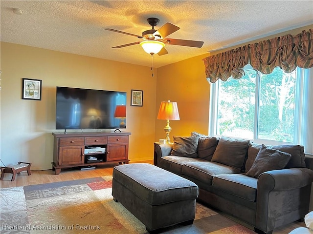 living room featuring ceiling fan, hardwood / wood-style floors, and a textured ceiling