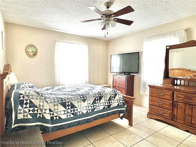 bedroom featuring a textured ceiling, ceiling fan, and light tile patterned flooring