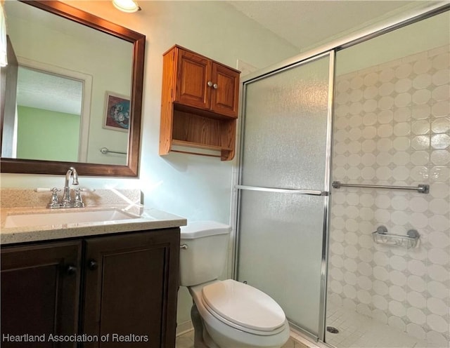 bathroom with vanity, toilet, and a shower with door