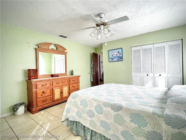 tiled bedroom featuring a textured ceiling, a closet, and ceiling fan