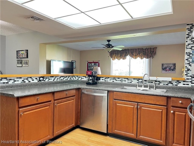 kitchen featuring dishwasher, sink, light hardwood / wood-style flooring, ceiling fan, and tasteful backsplash