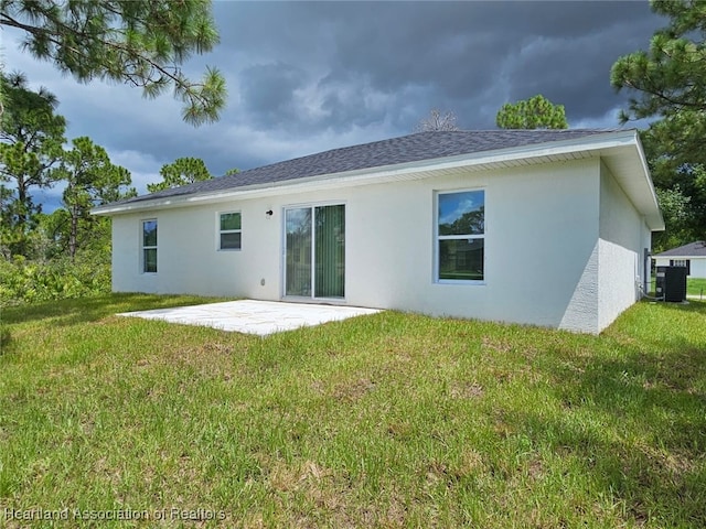 rear view of property with central air condition unit, a patio area, and a yard