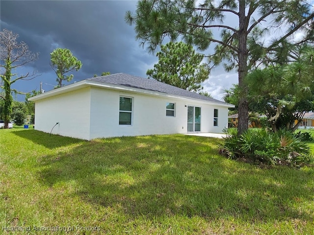 rear view of property featuring a lawn