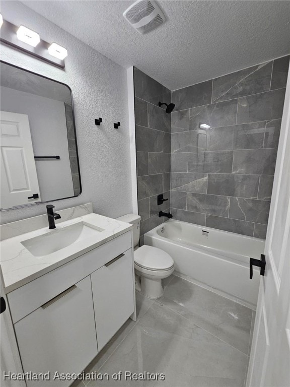 full bathroom featuring vanity, tiled shower / bath combo, a textured ceiling, and toilet