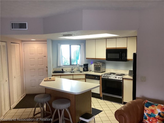 kitchen featuring white cabinetry, dishwasher, sink, light tile patterned floors, and range