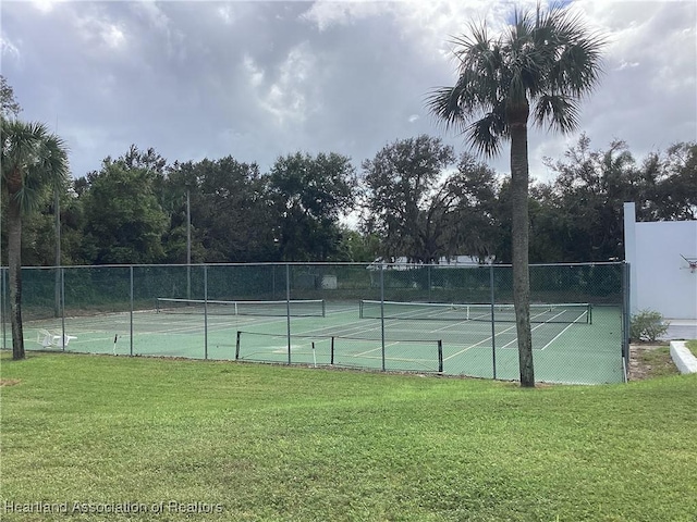 view of tennis court with a lawn