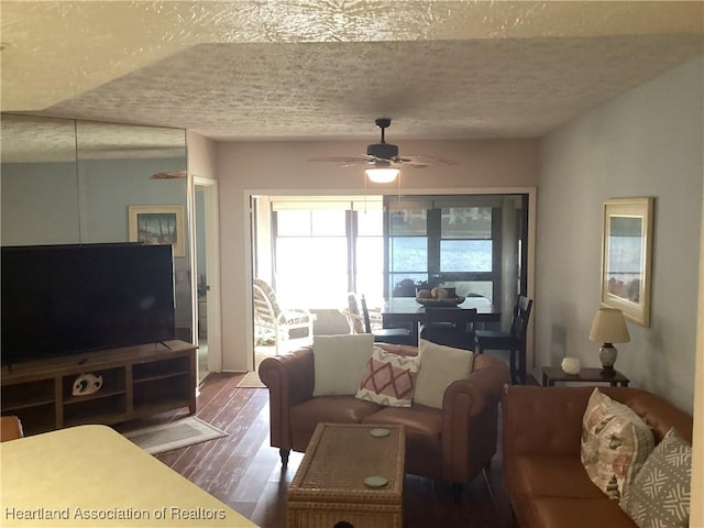 living room featuring hardwood / wood-style floors, a textured ceiling, and ceiling fan