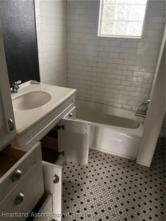 bathroom with tile patterned floors, tiled shower / bath, and sink