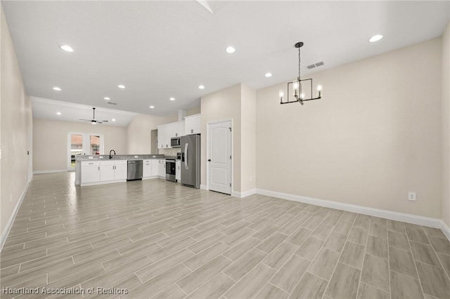4825 Whiting Dr, Sebring, FL 33870 - unfurnished living room with a sink, baseboards, visible vents, a notable chandelier, and light wood-style floors