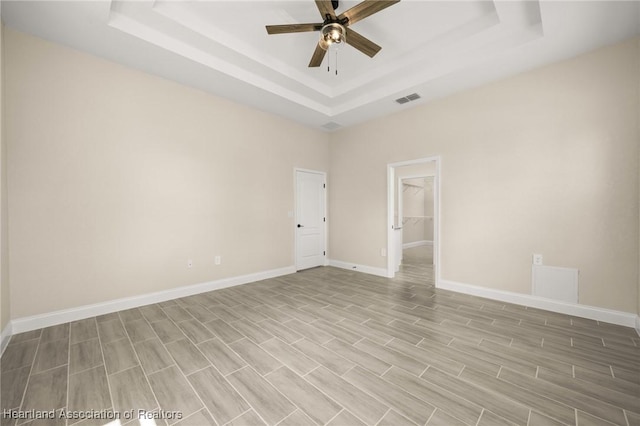 4825 Whiting Dr, Sebring, FL 33870 - unfurnished room featuring a tray ceiling, light wood-type flooring, visible vents, baseboards, and ceiling fan