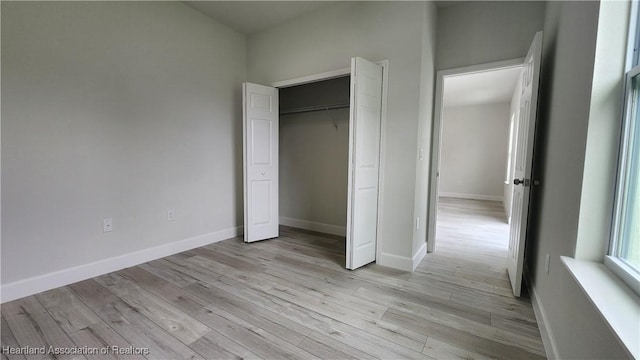 unfurnished bedroom with light wood-type flooring and a closet