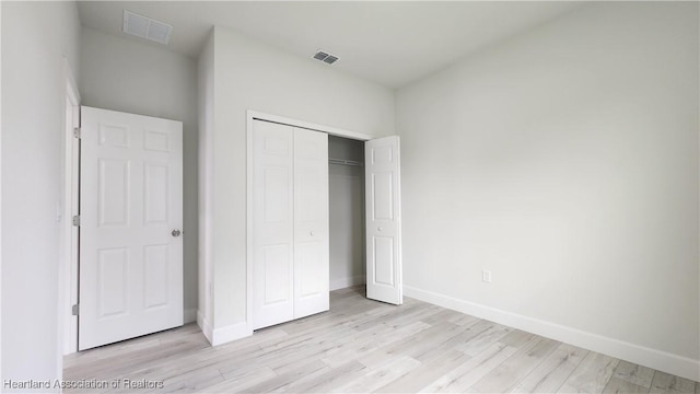 unfurnished bedroom featuring a closet and light hardwood / wood-style floors