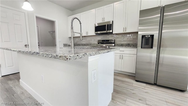 kitchen with white cabinetry, a kitchen island with sink, and appliances with stainless steel finishes