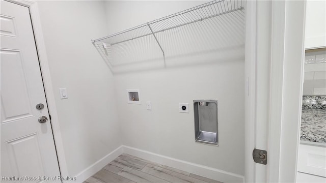 clothes washing area featuring washer hookup, electric dryer hookup, and light hardwood / wood-style flooring