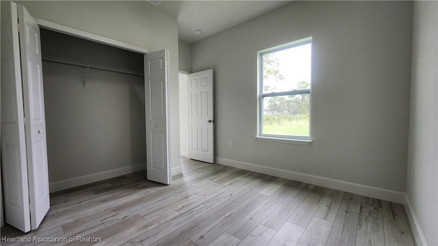 unfurnished bedroom with light wood-type flooring and a closet