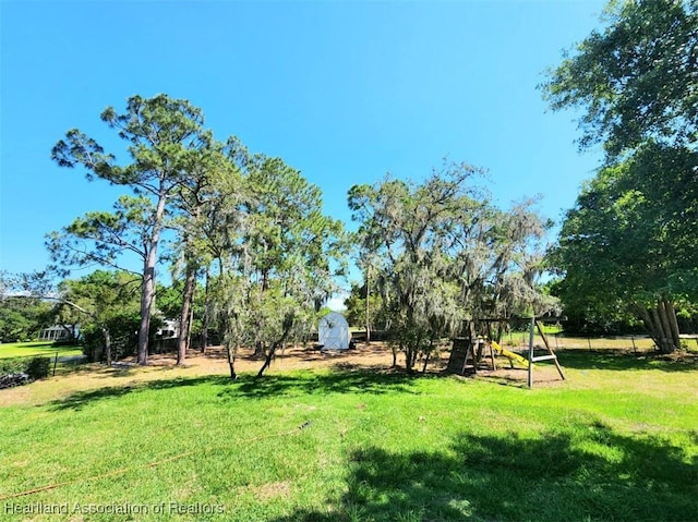 view of yard with a playground and a storage shed