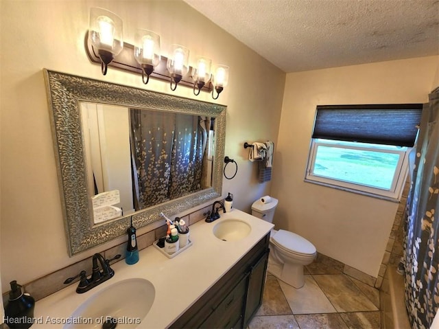 bathroom featuring vanity, toilet, and a textured ceiling