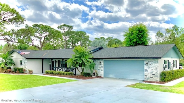 ranch-style house featuring a porch, a garage, and a front lawn