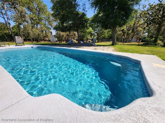 view of pool with a patio area and a yard