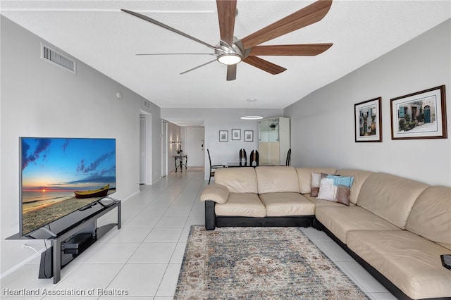 living room with ceiling fan, a textured ceiling, and light tile patterned floors