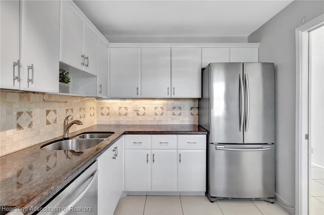 kitchen featuring white cabinets, dark stone counters, sink, and stainless steel appliances