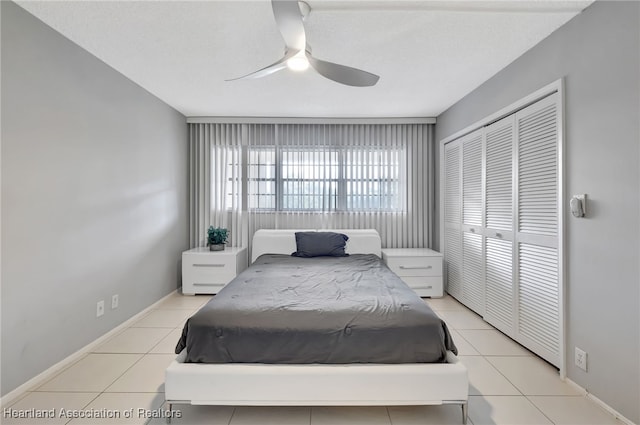 tiled bedroom with ceiling fan and a closet