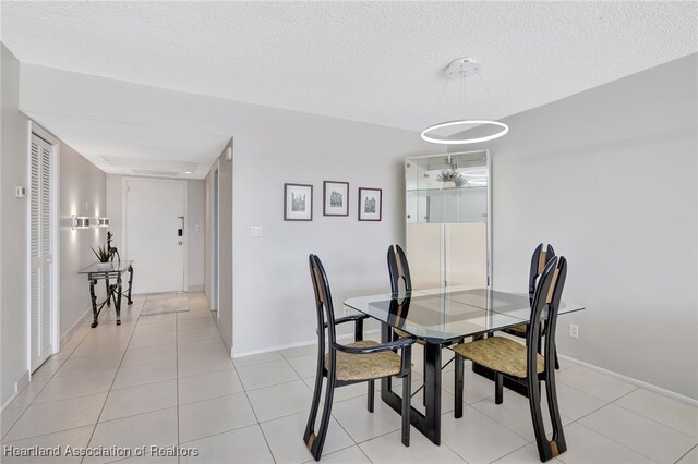 tiled dining space with a textured ceiling