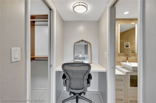 tiled home office featuring sink and a textured ceiling