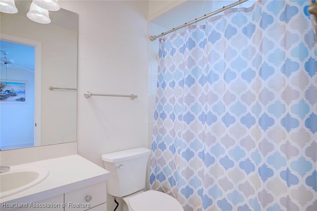 bathroom with walk in shower, vanity, and toilet