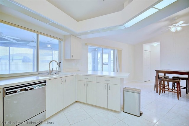 kitchen with kitchen peninsula, stainless steel dishwasher, ceiling fan, sink, and white cabinetry