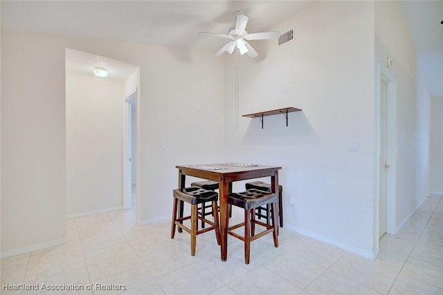 dining space with ceiling fan, light tile patterned flooring, and vaulted ceiling