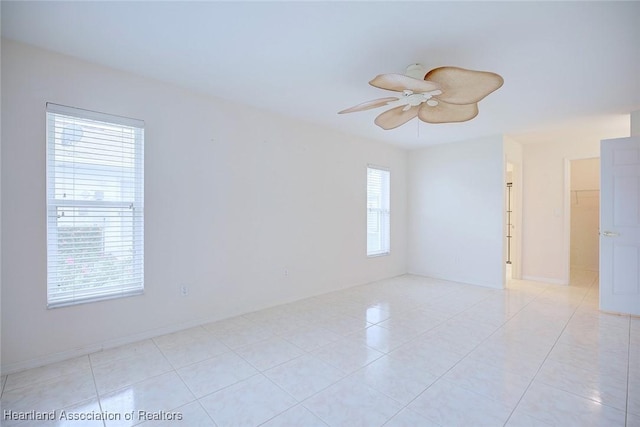 unfurnished room featuring plenty of natural light, ceiling fan, and light tile patterned floors