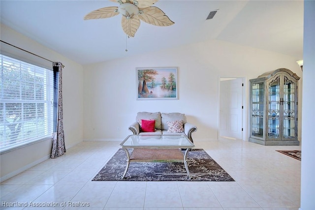 living room featuring ceiling fan, light tile patterned floors, and lofted ceiling