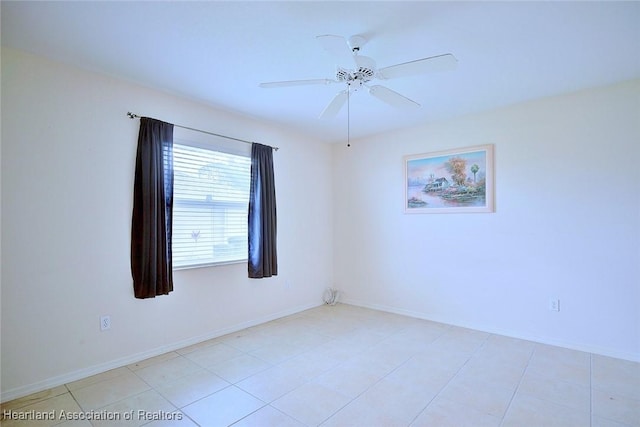 tiled spare room featuring ceiling fan