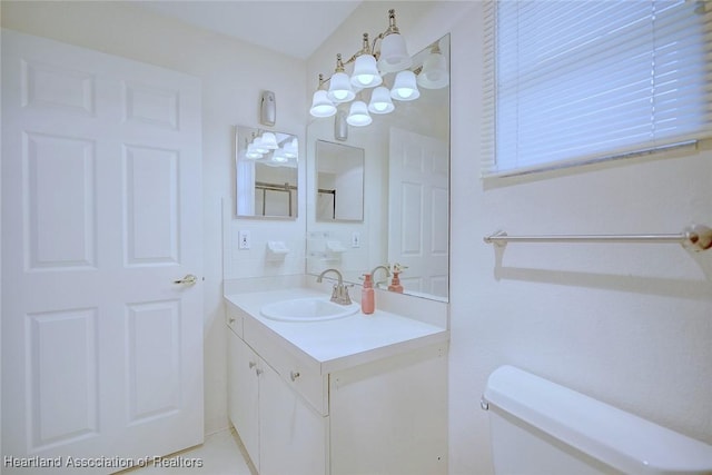 bathroom featuring a chandelier, tile patterned floors, vanity, and toilet