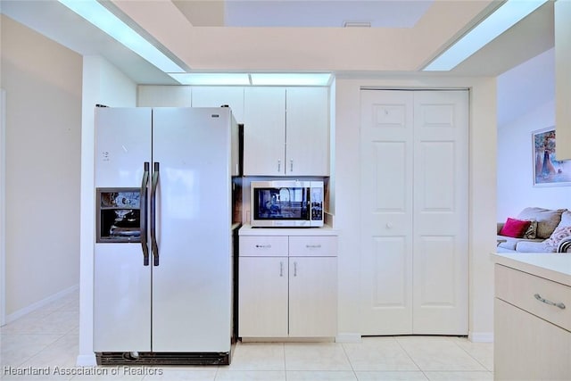 kitchen featuring white refrigerator with ice dispenser and light tile patterned floors