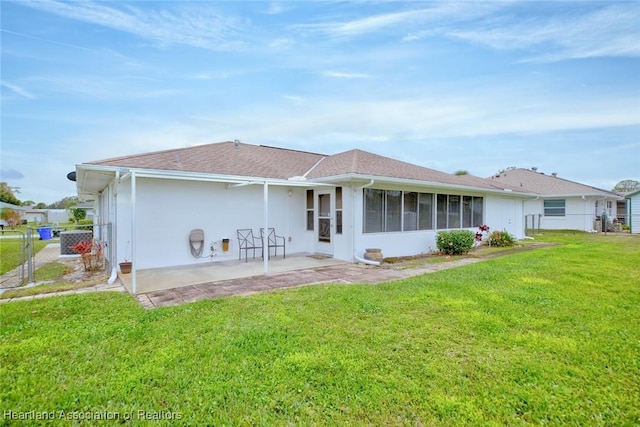 back of house featuring a sunroom, a patio area, and a lawn