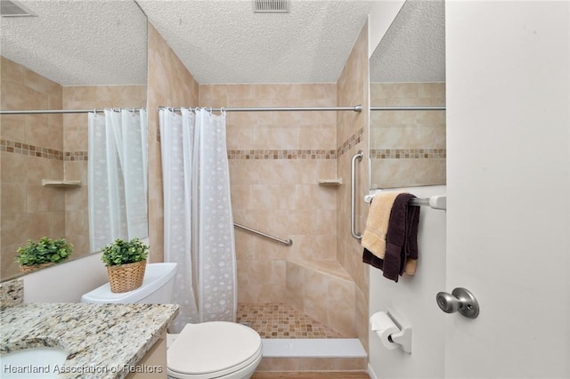 bathroom featuring walk in shower, vanity, a textured ceiling, and toilet