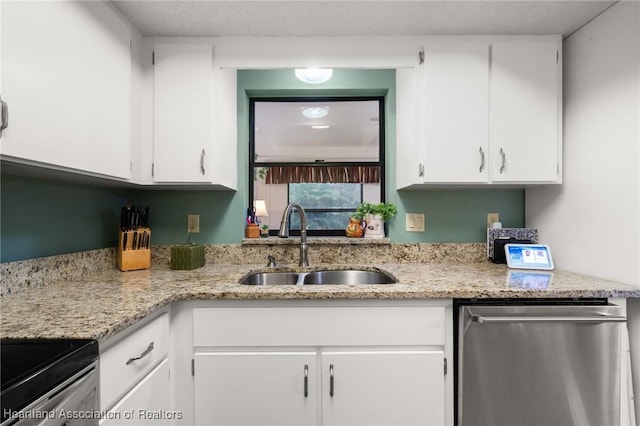 kitchen featuring light stone countertops, appliances with stainless steel finishes, sink, and white cabinets