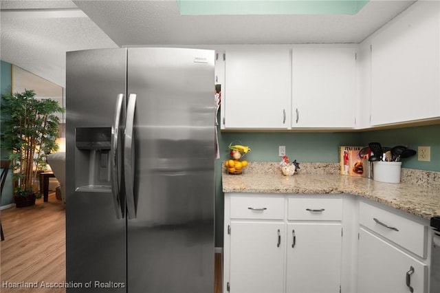 kitchen featuring light hardwood / wood-style flooring, white cabinets, light stone counters, and stainless steel fridge with ice dispenser