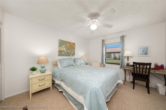 carpeted bedroom featuring ceiling fan and a textured ceiling